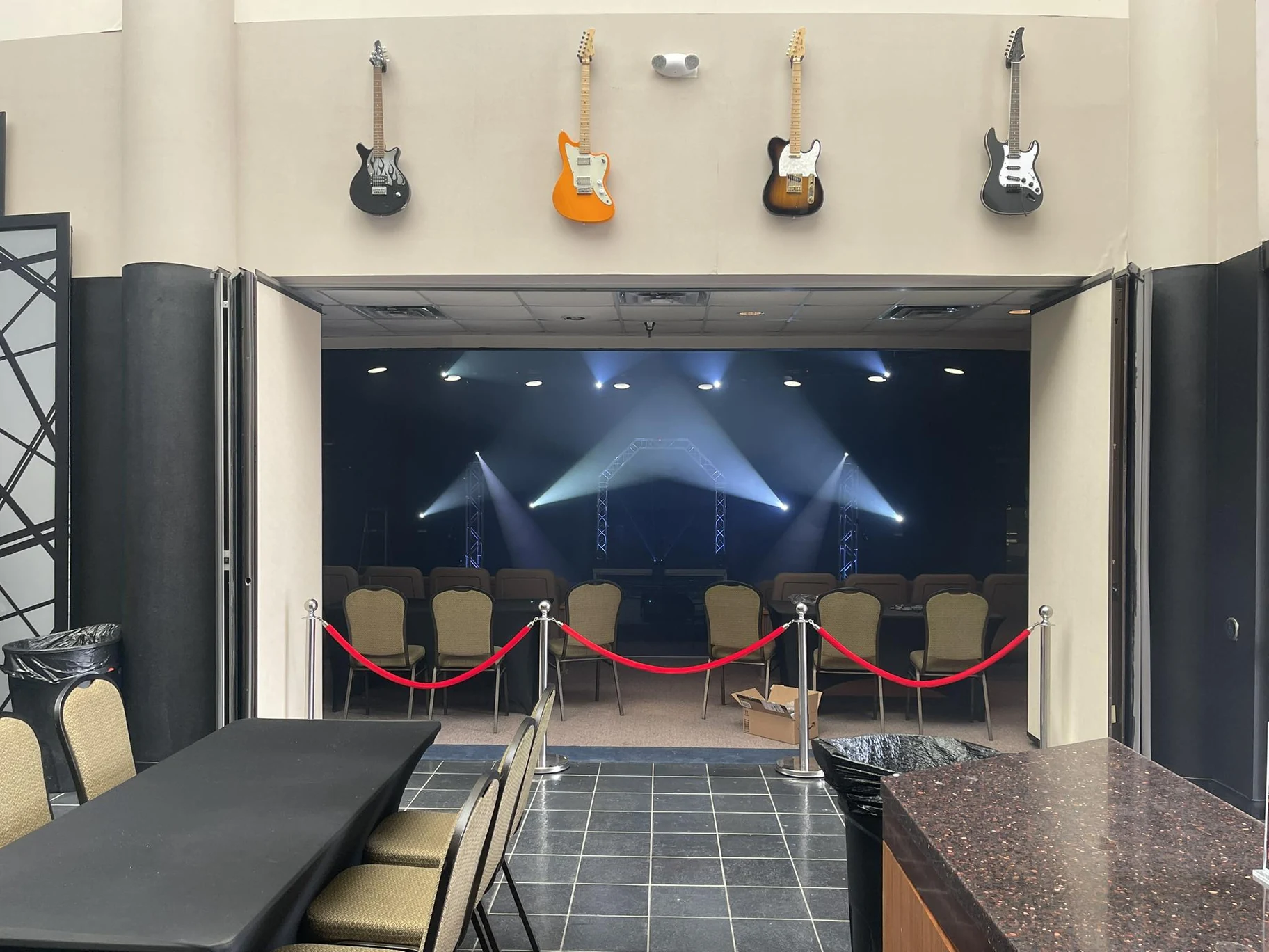 Concert hall entrance with guitars, seating, and stage lighting at Platinum NRH