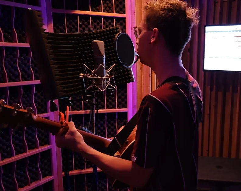 Musician recording vocals at a microphone